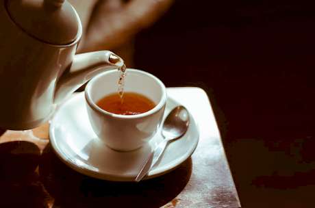 Teapot Pouring Tea into a Cup