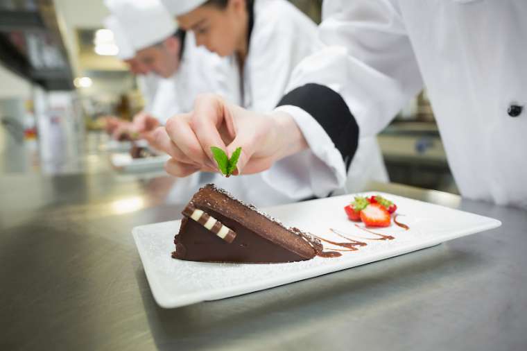 Chef Putting Mint on Chocolate Cake